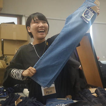 学生がジーンズを手に取って作業している写真