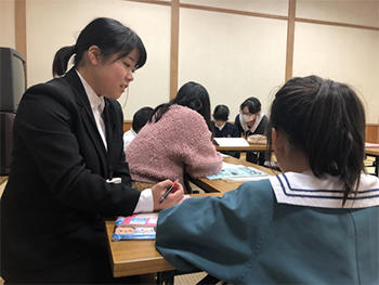 学生が放課後チャレンジ教室で小学生を指導している様子を撮影した写真